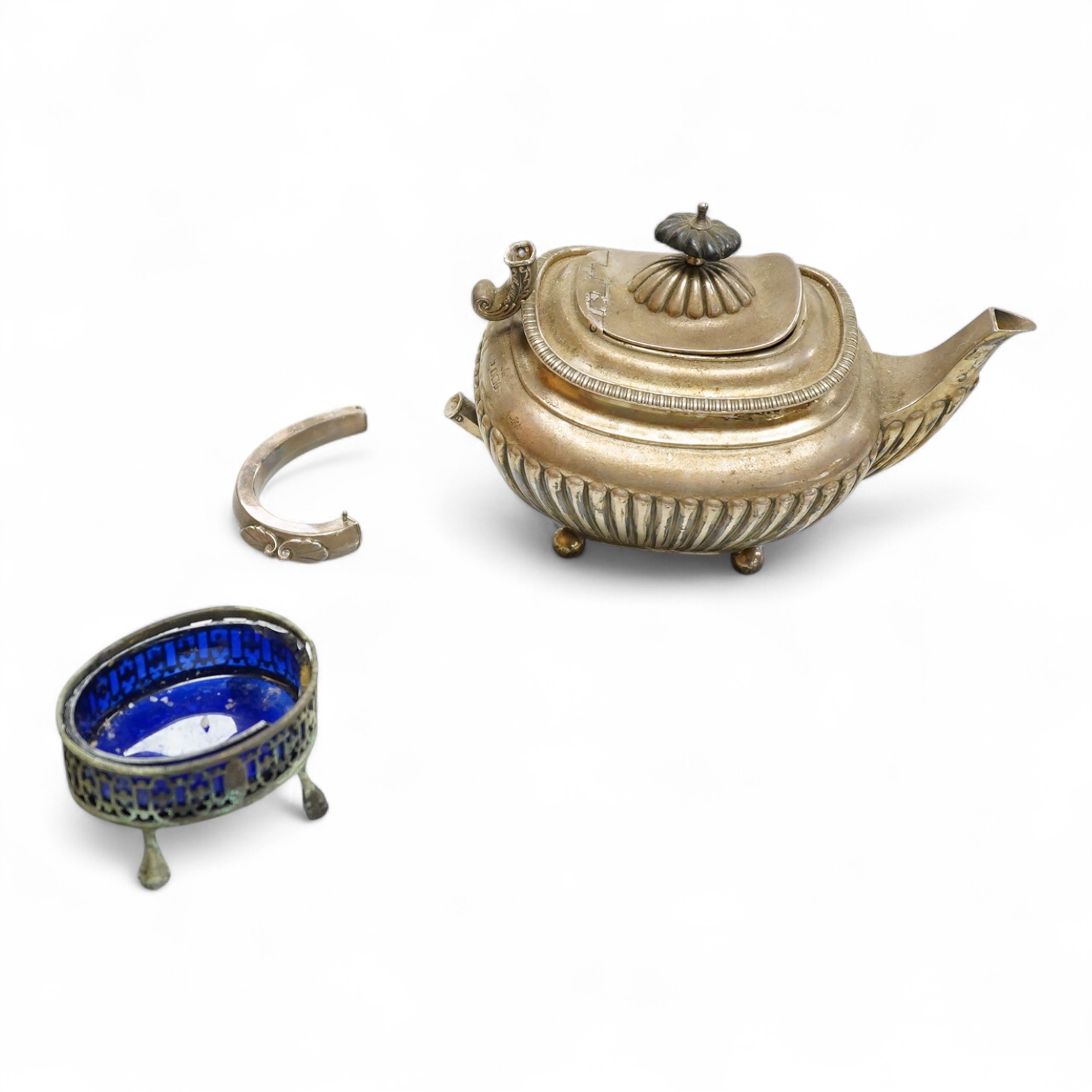 An early 20th century demi-fluted silver oval teapot, by James Dixon & Sons, Sheffield, 1903?, handle detached, together with a George III pierced silver oval salt, by Robert Hennell I, with glass liner(a.f.), gross weig